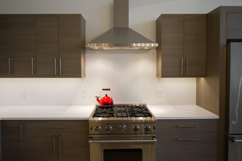 Exempel på ett mellanstort modernt kök, med en undermonterad diskho, släta luckor, grå skåp, bänkskiva i kvartsit, vitt stänkskydd, rostfria vitvaror och en köksö