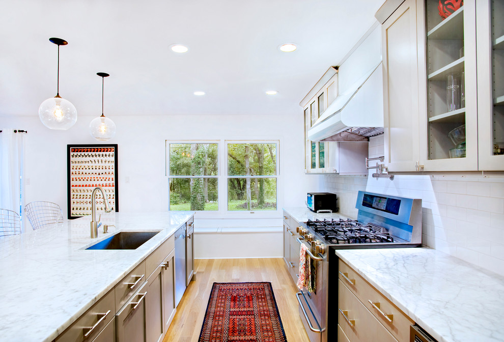 Imagen de cocina moderna con fregadero bajoencimera, armarios estilo shaker, puertas de armario beige, salpicadero blanco y salpicadero de azulejos tipo metro