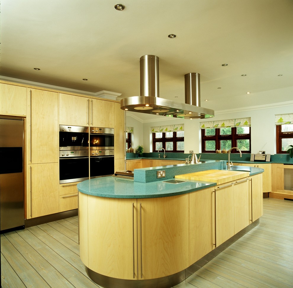 Exempel på ett mycket stort modernt kök med öppen planlösning, med släta luckor, skåp i ljust trä, bänkskiva i kvartsit, rostfria vitvaror, ljust trägolv och en köksö