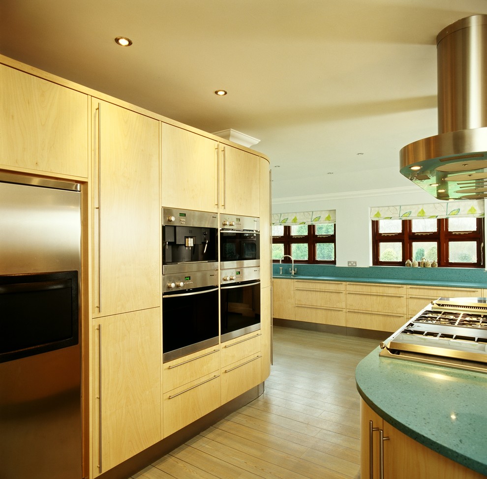 Offene, Geräumige Moderne Küche mit flächenbündigen Schrankfronten, hellen Holzschränken, Quarzit-Arbeitsplatte, Küchengeräten aus Edelstahl, hellem Holzboden und Kücheninsel in Buckinghamshire