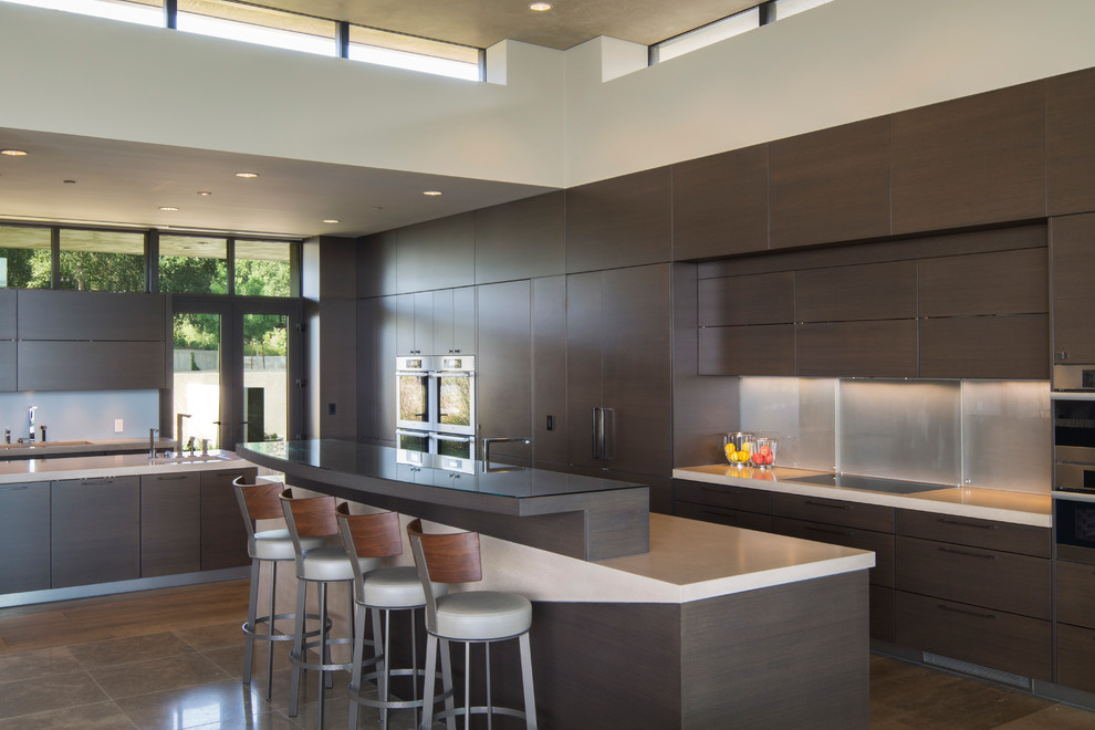 Inspiration for an expansive modern l-shaped kitchen pantry in San Francisco with a submerged sink, flat-panel cabinets, dark wood cabinets, concrete worktops, integrated appliances, travertine flooring and multiple islands.