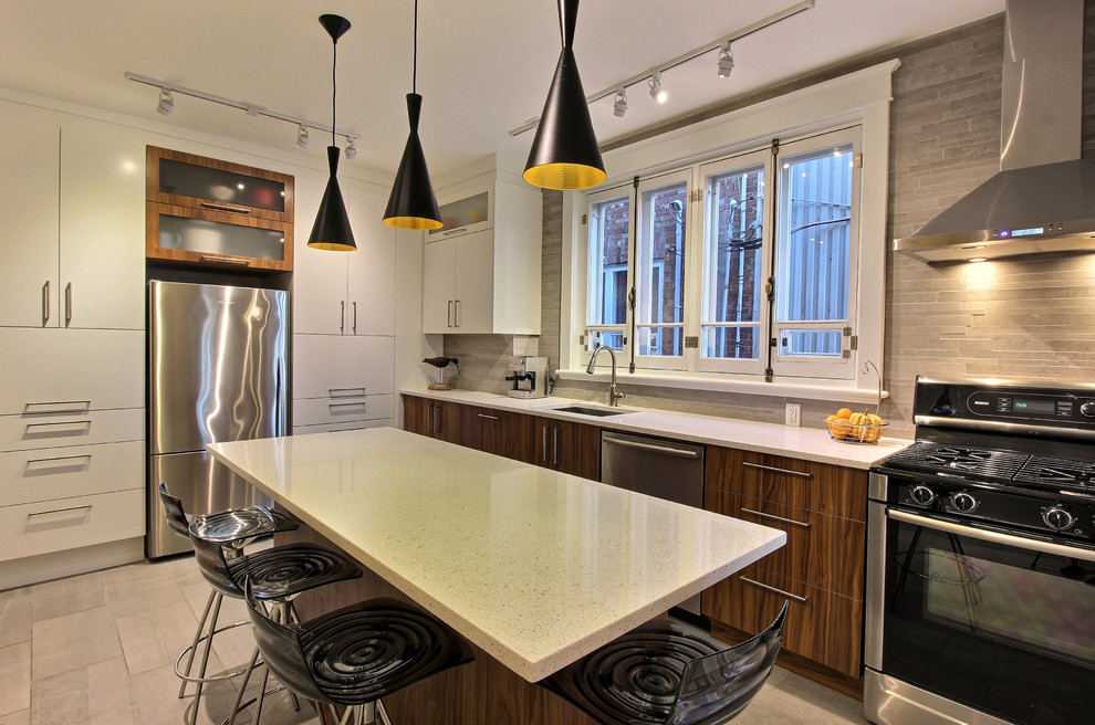 Example of a mid-sized trendy single-wall ceramic tile and gray floor eat-in kitchen design in Montreal with an undermount sink, flat-panel cabinets, dark wood cabinets, quartz countertops, gray backsplash, stone tile backsplash, stainless steel appliances and an island