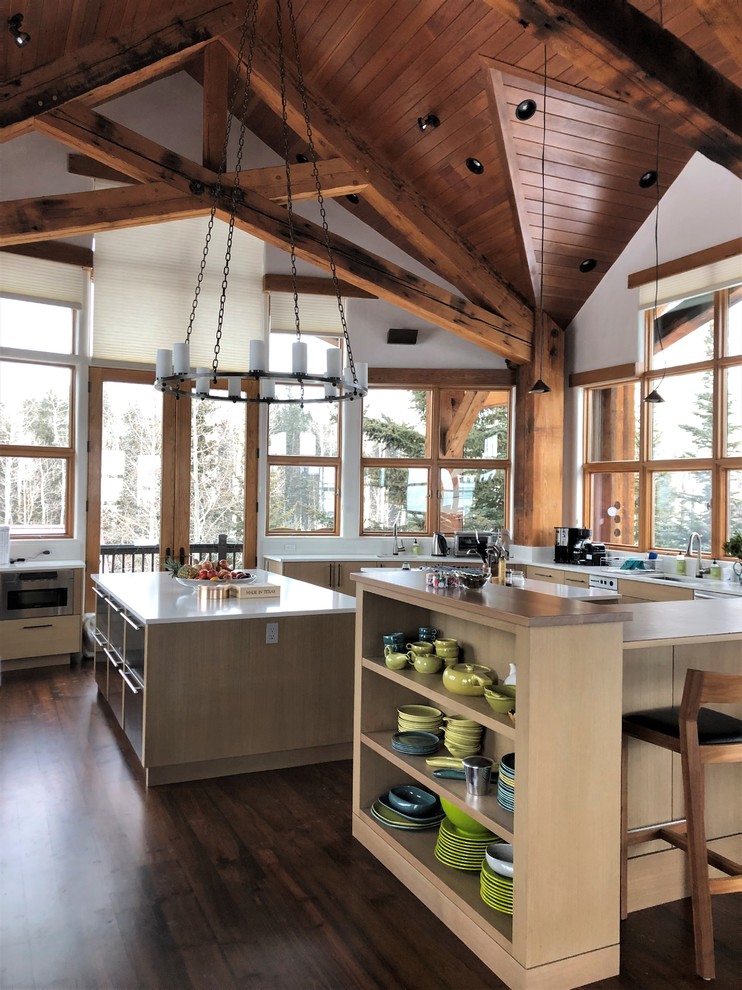 Eat-in kitchen - huge rustic u-shaped dark wood floor and brown floor eat-in kitchen idea in Denver with an undermount sink, flat-panel cabinets, light wood cabinets, stainless steel appliances, two islands and white countertops