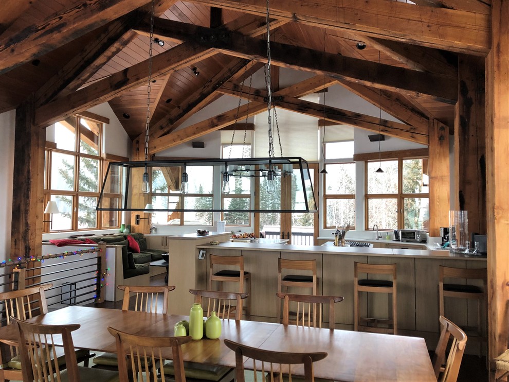Inspiration for a huge rustic u-shaped dark wood floor and brown floor eat-in kitchen remodel in Denver with an undermount sink, flat-panel cabinets, light wood cabinets, stainless steel appliances, two islands and white countertops