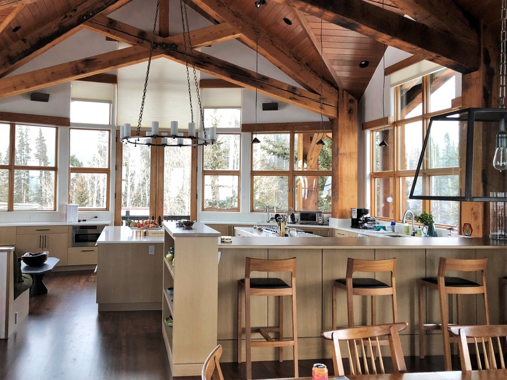 Huge mountain style u-shaped dark wood floor and brown floor eat-in kitchen photo in Denver with an undermount sink, flat-panel cabinets, light wood cabinets, stainless steel appliances, two islands and white countertops