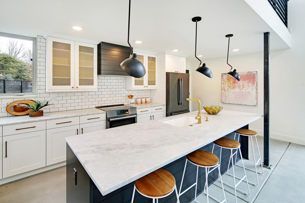 Design ideas for a large contemporary galley open plan kitchen in Seattle with a built-in sink, recessed-panel cabinets, white cabinets, marble worktops, white splashback, ceramic splashback, black appliances, an island and grey worktops.