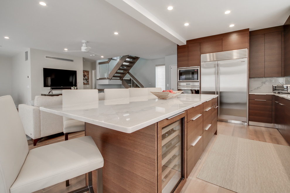 Inspiration for a large contemporary u-shaped light wood floor eat-in kitchen remodel in Philadelphia with an undermount sink, flat-panel cabinets, dark wood cabinets, quartzite countertops, white backsplash, stone slab backsplash, stainless steel appliances and an island