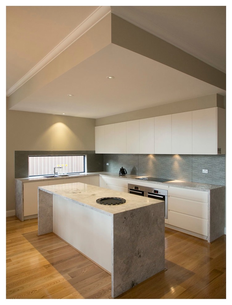 This is an example of a modern kitchen/diner in Melbourne with a double-bowl sink, flat-panel cabinets, white cabinets, marble worktops, metallic splashback, glass sheet splashback, stainless steel appliances, light hardwood flooring and an island.