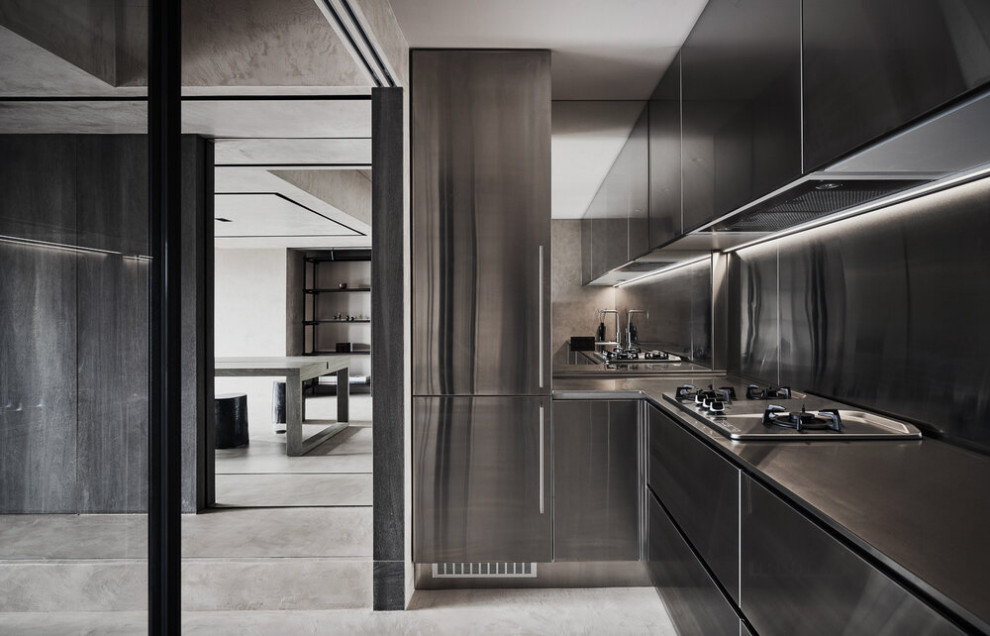 Ejemplo de cocina actual con armarios con paneles lisos, puertas de armario en acero inoxidable, encimera de acero inoxidable y electrodomésticos de acero inoxidable