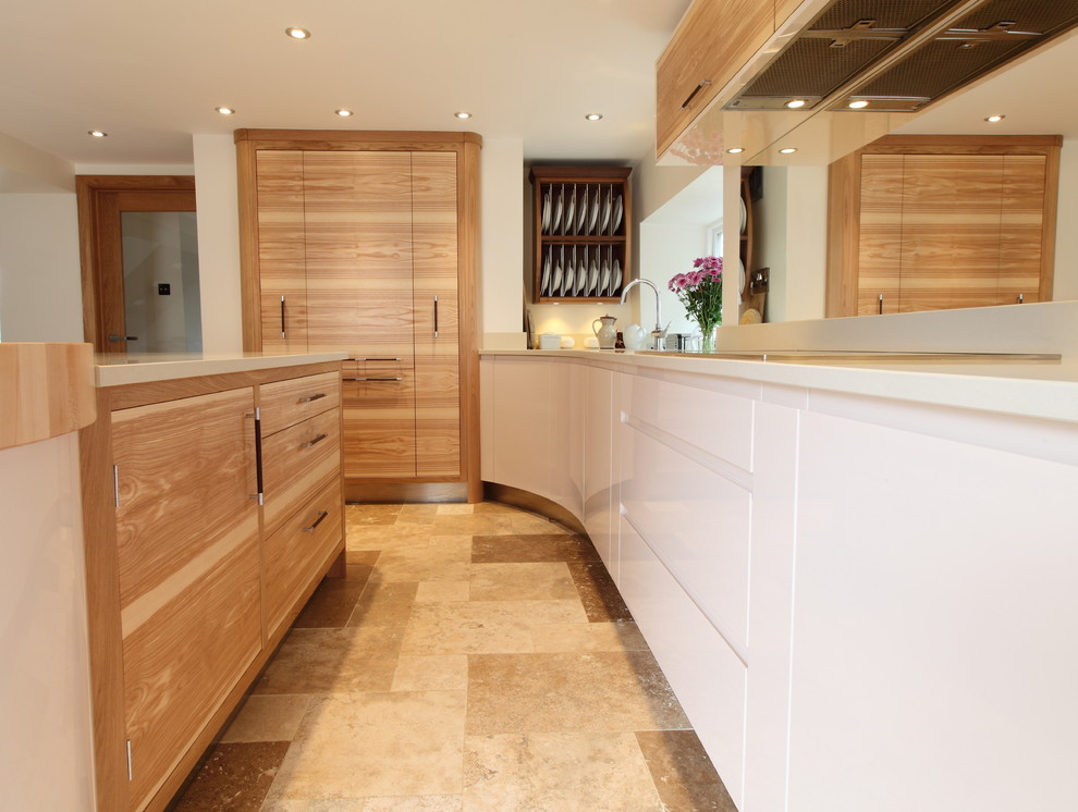 Eat-in kitchen - mid-sized contemporary l-shaped travertine floor eat-in kitchen idea in Manchester with an undermount sink, flat-panel cabinets, light wood cabinets, quartz countertops, glass sheet backsplash and stainless steel appliances