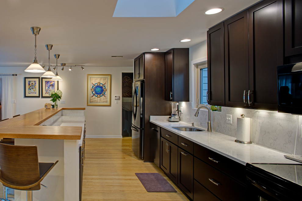 Inspiration for a small contemporary galley bamboo floor kitchen remodel in Baltimore with an undermount sink, shaker cabinets, quartz countertops, stone tile backsplash, black appliances and an island
