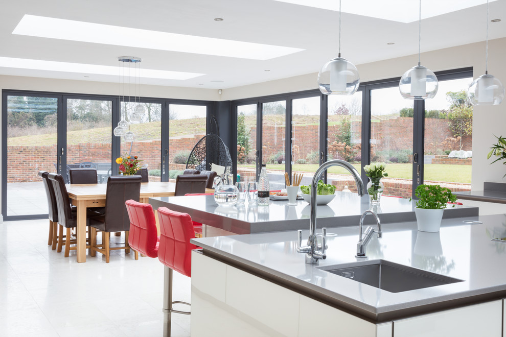 Offene, Mittelgroße Moderne Küche mit Quarzit-Arbeitsplatte, Küchengeräten aus Edelstahl, Kücheninsel und weißem Boden in Hampshire