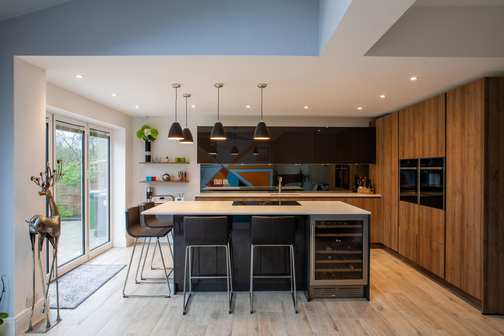 This is an example of a contemporary u-shaped open plan kitchen in Other with engineered stone countertops, grey splashback, a submerged sink, flat-panel cabinets, medium wood cabinets, glass sheet splashback, integrated appliances, medium hardwood flooring, an island, brown floors and white worktops.