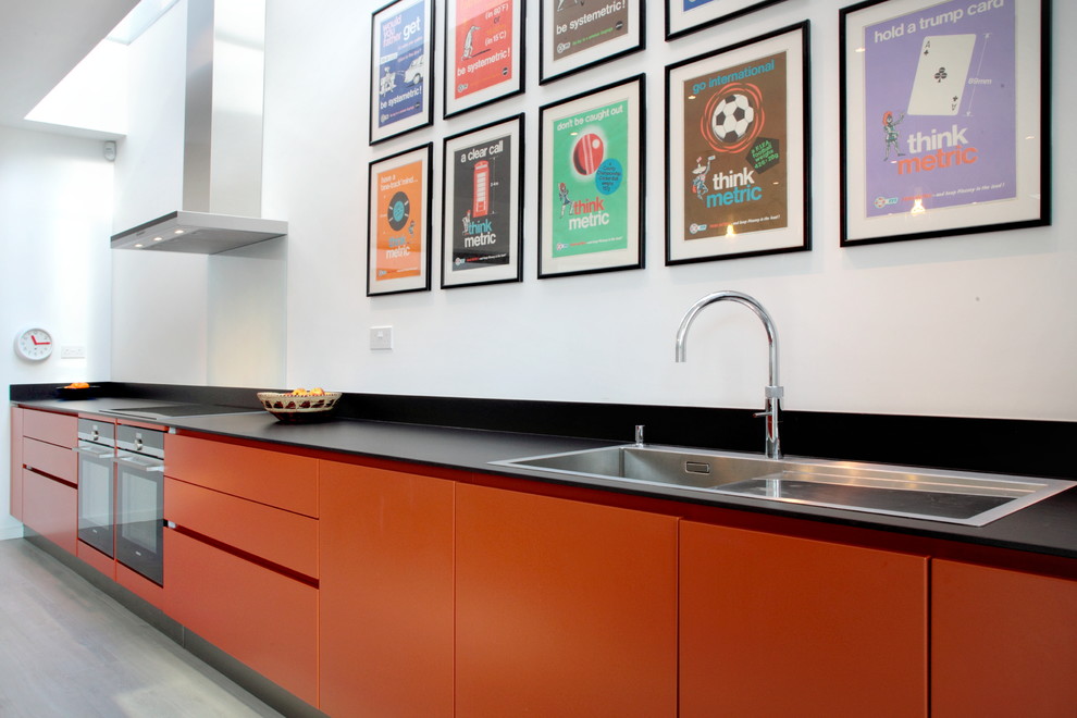Esempio di una grande cucina design con ante lisce, ante arancioni, paraspruzzi blu, paraspruzzi con lastra di vetro, elettrodomestici in acciaio inossidabile, lavello da incasso, top in quarzite e parquet scuro