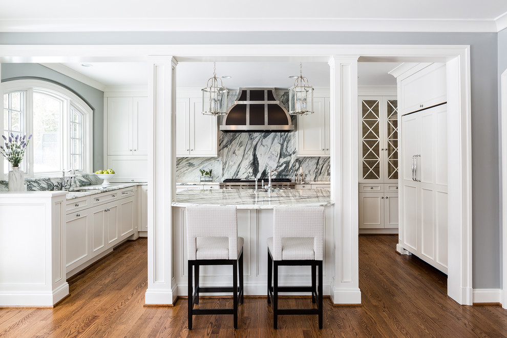 Foto på ett mellanstort vintage kök, med en nedsänkt diskho, luckor med infälld panel, vita skåp, marmorbänkskiva, flerfärgad stänkskydd, stänkskydd i marmor, rostfria vitvaror, en köksö och mörkt trägolv