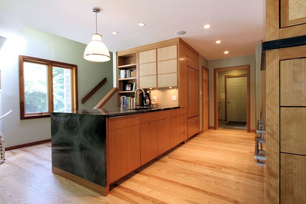 Inspiration for a contemporary eat-in kitchen remodel in Indianapolis with flat-panel cabinets, medium tone wood cabinets, granite countertops and paneled appliances