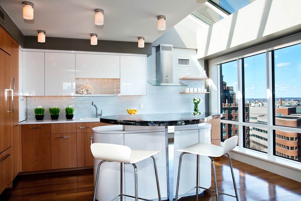 Moderne Küche mit flächenbündigen Schrankfronten, weißen Schränken, Küchenrückwand in Weiß und Elektrogeräten mit Frontblende in Boston