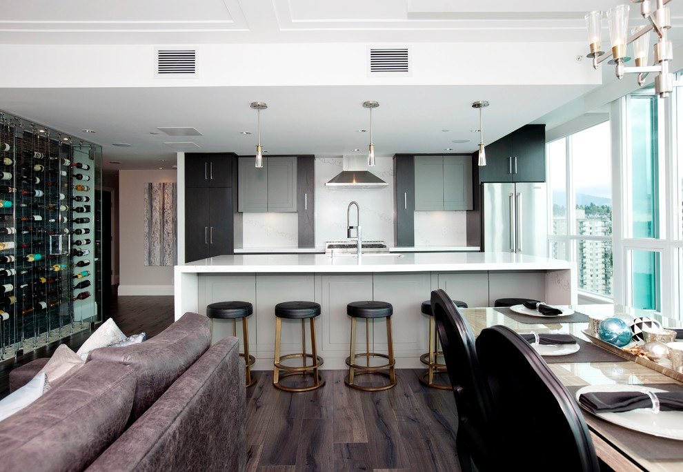 Large contemporary single-wall open plan kitchen in Vancouver with a submerged sink, flat-panel cabinets, dark wood cabinets, quartz worktops, white splashback, stone tiled splashback, stainless steel appliances, dark hardwood flooring and an island.