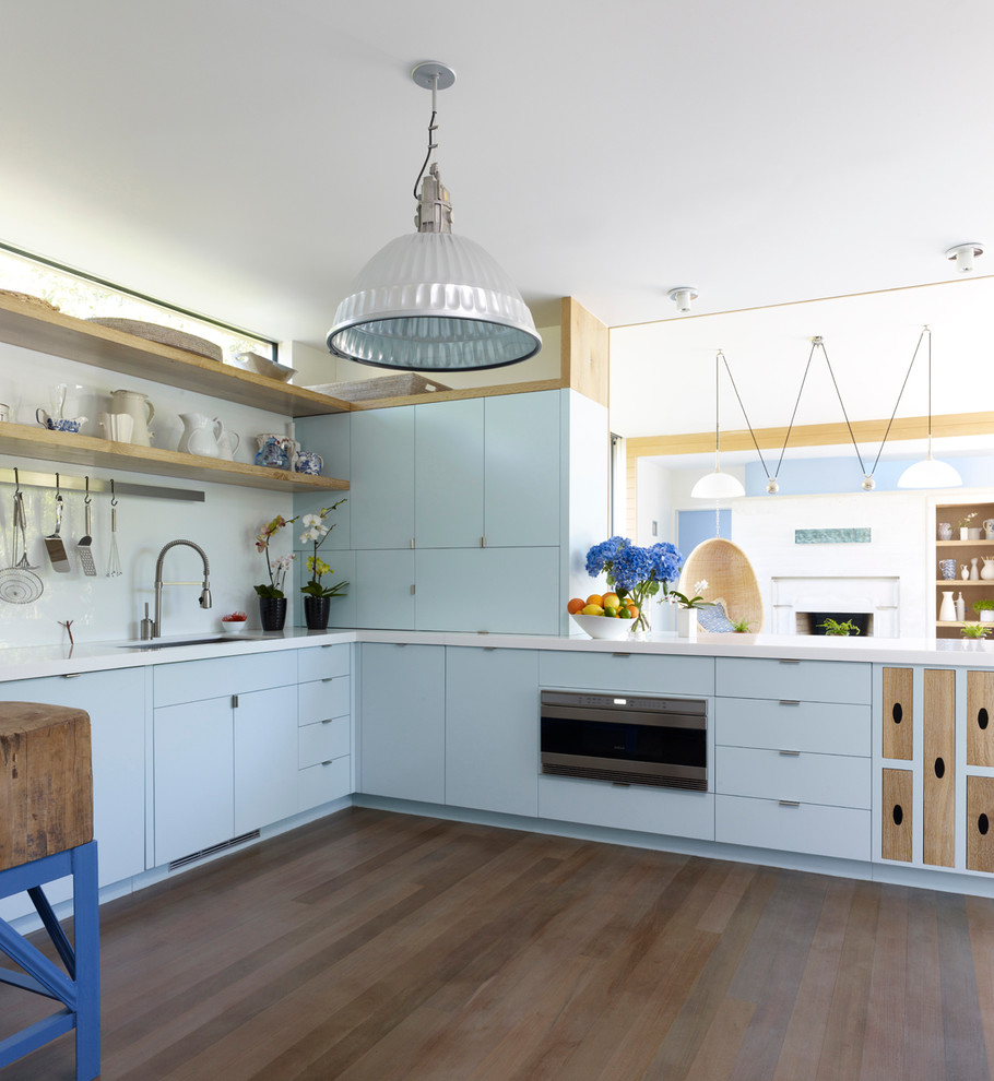Пример оригинального дизайна: угловая кухня в современном стиле с плоскими фасадами и синими фасадами