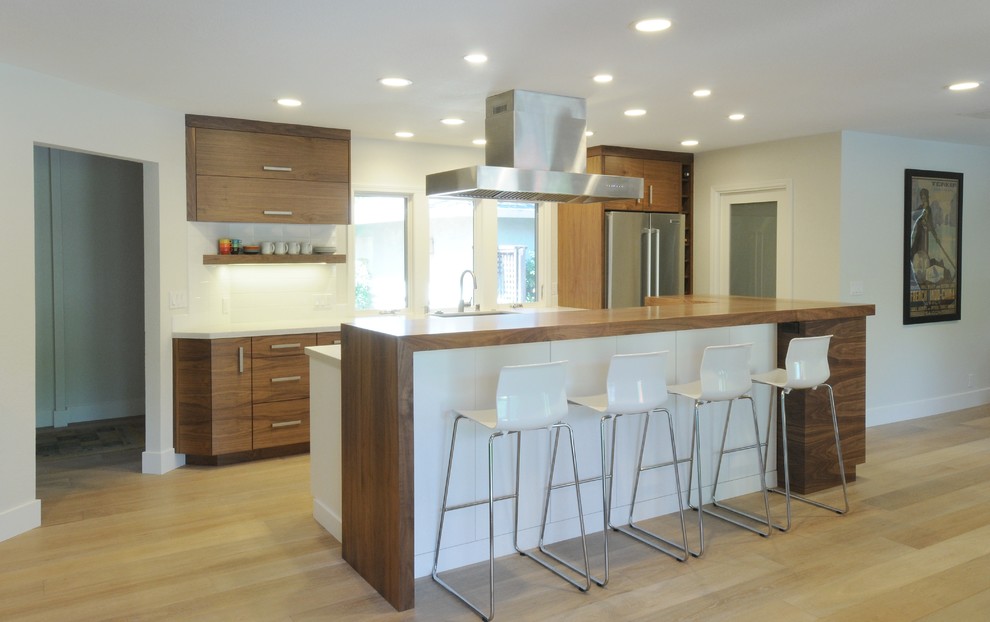Inspiration for a mid-sized contemporary single-wall eat-in kitchen remodel in Sacramento with an undermount sink, flat-panel cabinets, medium tone wood cabinets, quartz countertops, white backsplash, subway tile backsplash, stainless steel appliances and an island