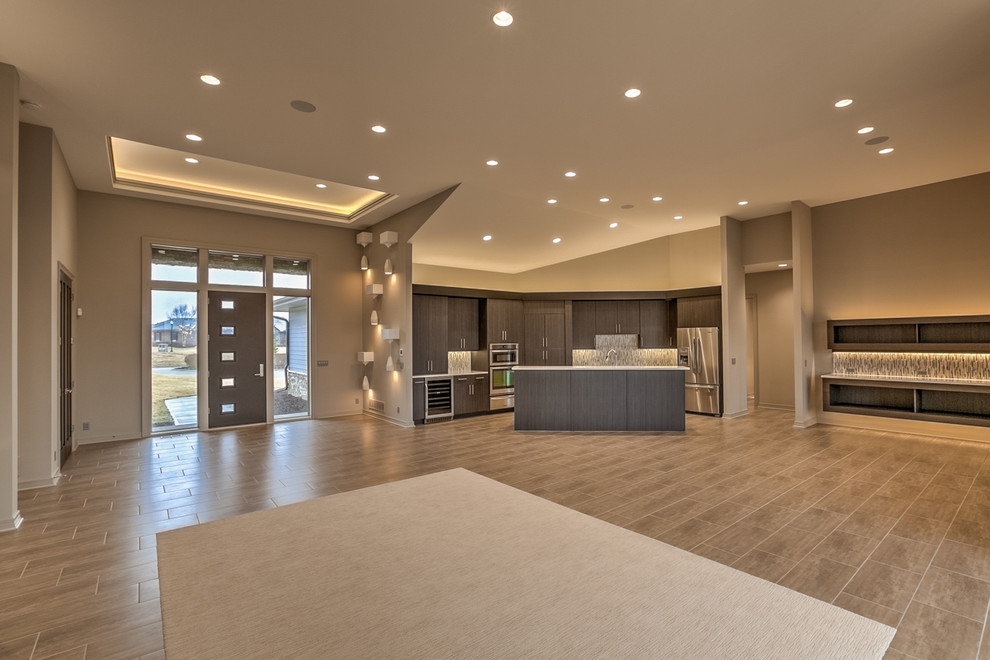 Eat-in kitchen - large contemporary l-shaped porcelain tile and beige floor eat-in kitchen idea in Omaha with flat-panel cabinets, dark wood cabinets, quartz countertops, gray backsplash, stainless steel appliances, an island, an undermount sink and glass tile backsplash