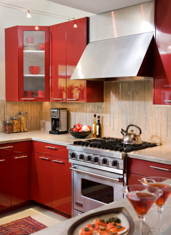 Mittelgroße Moderne Küche in U-Form mit Unterbauwaschbecken, flächenbündigen Schrankfronten, roten Schränken, Kalkstein-Arbeitsplatte, Küchenrückwand in Grau, Küchengeräten aus Edelstahl und Betonboden in San Diego