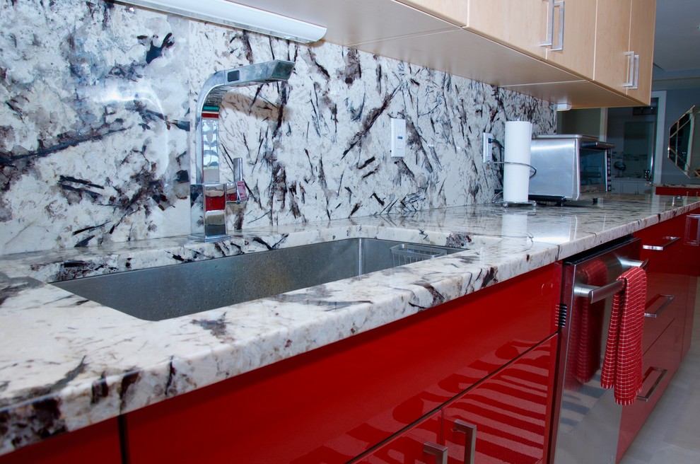 Kitchen - large contemporary galley kitchen idea in Miami with an undermount sink, flat-panel cabinets, red cabinets, granite countertops, stainless steel appliances and a peninsula