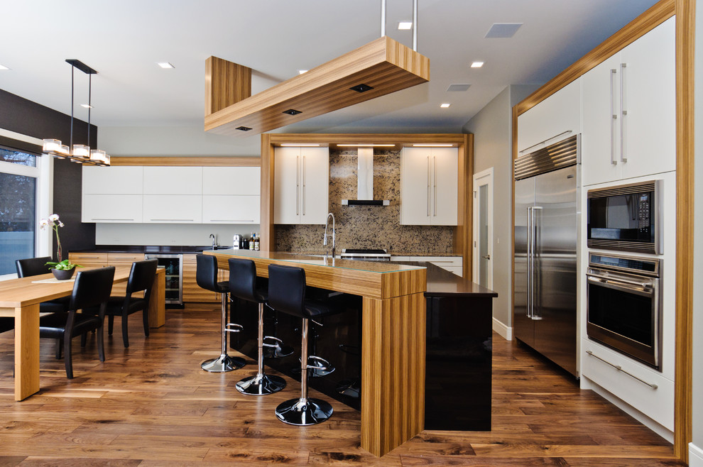 Inspiration for a mid-sized contemporary l-shaped medium tone wood floor and brown floor eat-in kitchen remodel in Calgary with flat-panel cabinets, white cabinets, multicolored backsplash, stainless steel appliances, quartz countertops, an island, an undermount sink and stone slab backsplash