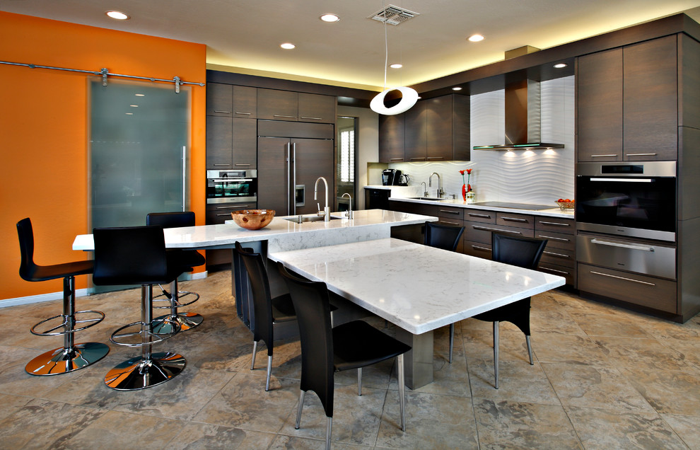 フェニックスにある広いコンテンポラリースタイルのおしゃれなキッチン (フラットパネル扉のキャビネット、濃色木目調キャビネット、白いキッチンパネル、パネルと同色の調理設備、アンダーカウンターシンク、セラミックタイルの床、茶色い床) の写真