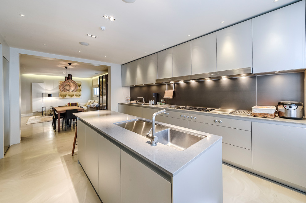 Inspiration for a large contemporary single-wall open plan kitchen in London with a double-bowl sink, flat-panel cabinets, grey cabinets, integrated appliances, an island and beige floors.