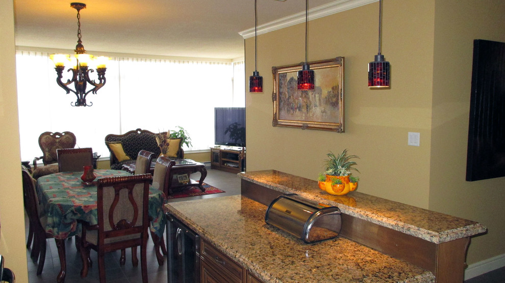 Foto på ett mellanstort vintage kök och matrum, med en dubbel diskho, luckor med upphöjd panel, skåp i mellenmörkt trä, granitbänkskiva, brunt stänkskydd, rostfria vitvaror, klinkergolv i keramik och en köksö