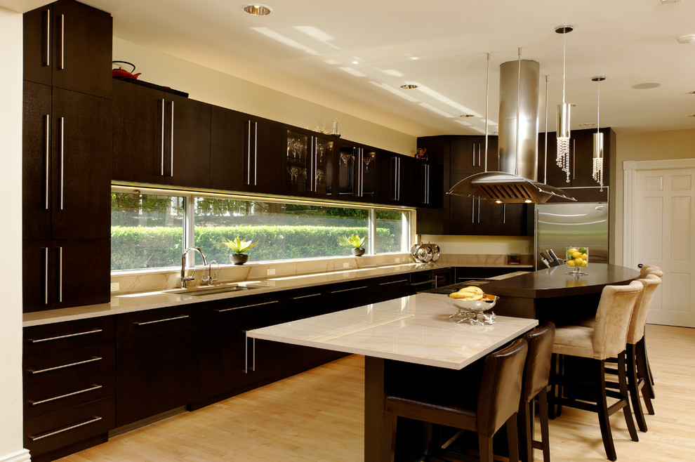 Photo of a contemporary kitchen/diner in DC Metro with flat-panel cabinets, brown cabinets, marble worktops, glass sheet splashback, stainless steel appliances, light hardwood flooring and an island.