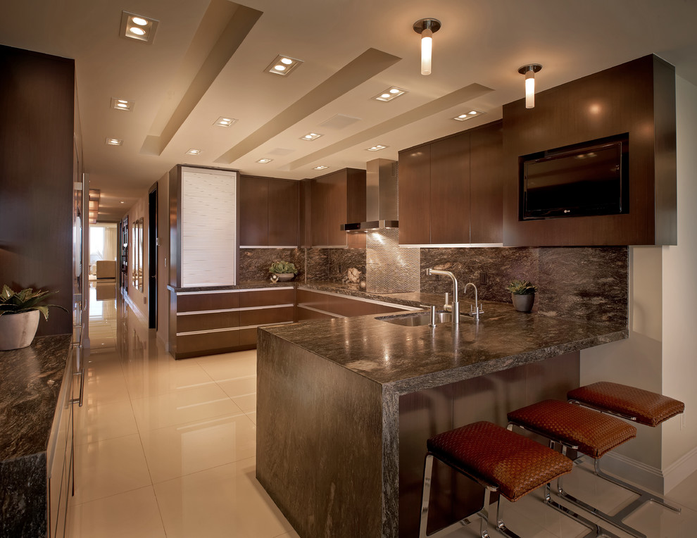 Geschlossene Moderne Küche in U-Form mit Unterbauwaschbecken, dunklen Holzschränken, Granit-Arbeitsplatte und Elektrogeräten mit Frontblende in Miami