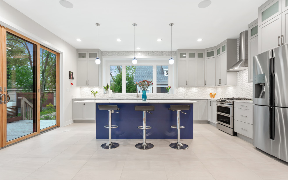 This is an example of a medium sized traditional l-shaped open plan kitchen in Chicago with shaker cabinets, grey cabinets, quartz worktops, grey splashback, ceramic splashback, stainless steel appliances, porcelain flooring, an island, beige floors and white worktops.