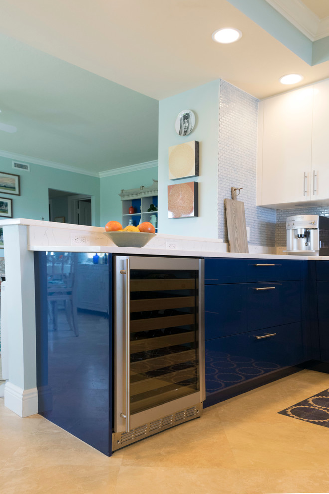 Esempio di una cucina design di medie dimensioni con ante lisce, top in quarzo composito, paraspruzzi blu, elettrodomestici in acciaio inossidabile, nessuna isola, lavello sottopiano, ante blu, paraspruzzi con piastrelle di vetro, pavimento in laminato e pavimento beige