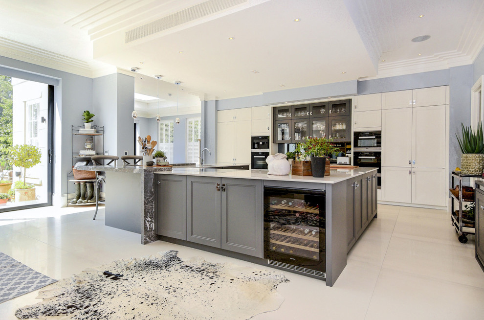 Design ideas for a large modern u-shaped open plan kitchen in Berkshire with a built-in sink, shaker cabinets, grey cabinets, granite worktops, grey splashback, mirror splashback, integrated appliances, an island and white worktops.