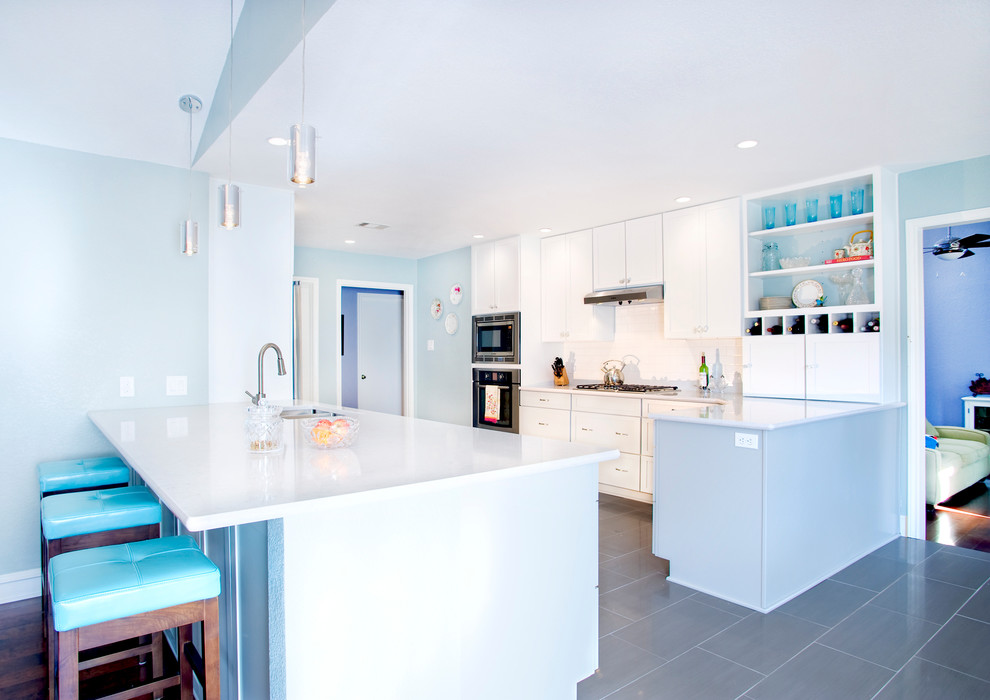 Inspiration for a modern kitchen in Austin with shaker cabinets, white cabinets, white splashback, stainless steel appliances and grey floors.