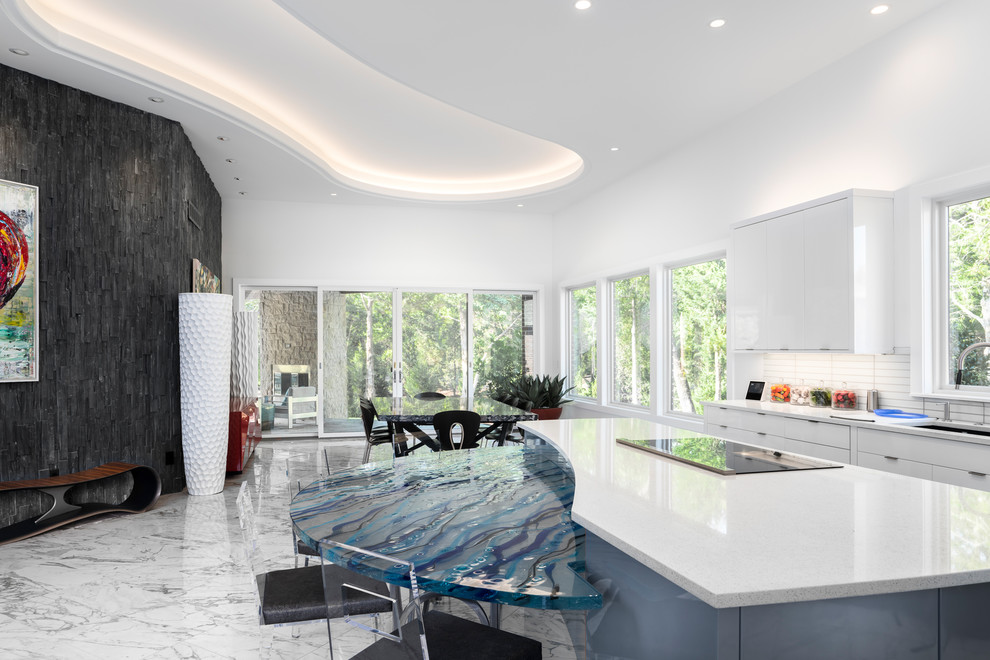 Bild på ett funkis vit vitt kök och matrum, med en undermonterad diskho, släta luckor, vita skåp, vitt stänkskydd, en köksö och flerfärgat golv