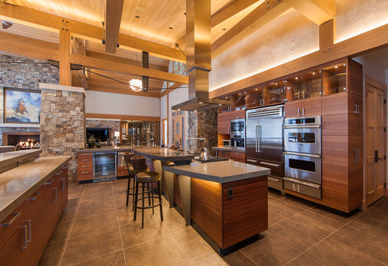 Cette image montre une grande cuisine ouverte design en bois brun avec un placard à porte plane, un électroménager en acier inoxydable, 2 îlots et un plan de travail gris.