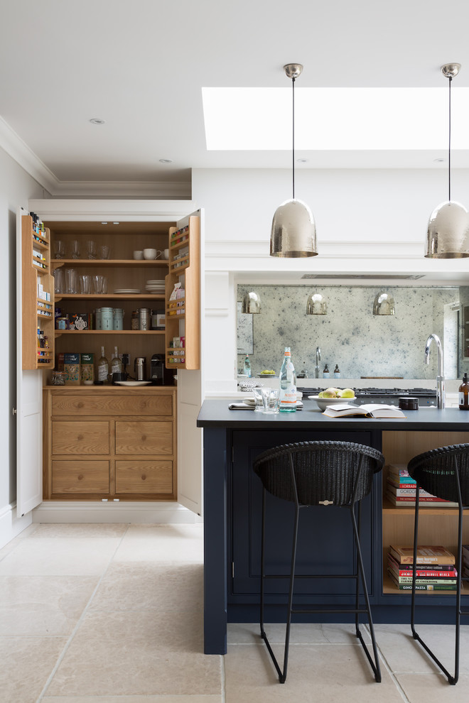 エセックスにあるラグジュアリーな中くらいなトランジショナルスタイルのおしゃれなアイランドキッチン (ベージュの床、ミラータイルのキッチンパネル、トラバーチンの床) の写真