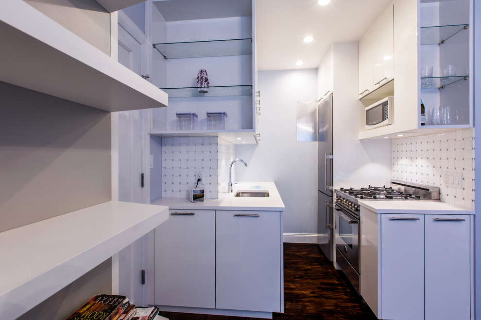 Modern inredning av ett litet kök, med en undermonterad diskho, släta luckor, vita skåp, bänkskiva i kvarts, vitt stänkskydd, stänkskydd i mosaik, rostfria vitvaror och mörkt trägolv