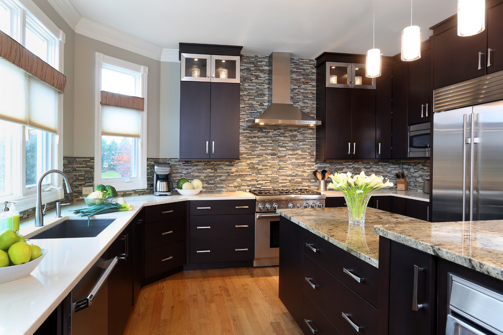 Example of a large trendy u-shaped light wood floor eat-in kitchen design in Chicago with an undermount sink, flat-panel cabinets, dark wood cabinets, granite countertops, multicolored backsplash, mosaic tile backsplash, stainless steel appliances and an island