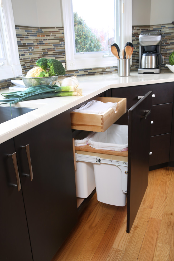 Foto de cocina contemporánea grande con fregadero bajoencimera, armarios con paneles lisos, puertas de armario negras, encimera de cuarzo compacto, salpicadero beige, salpicadero con mosaicos de azulejos, electrodomésticos de acero inoxidable y suelo de madera clara