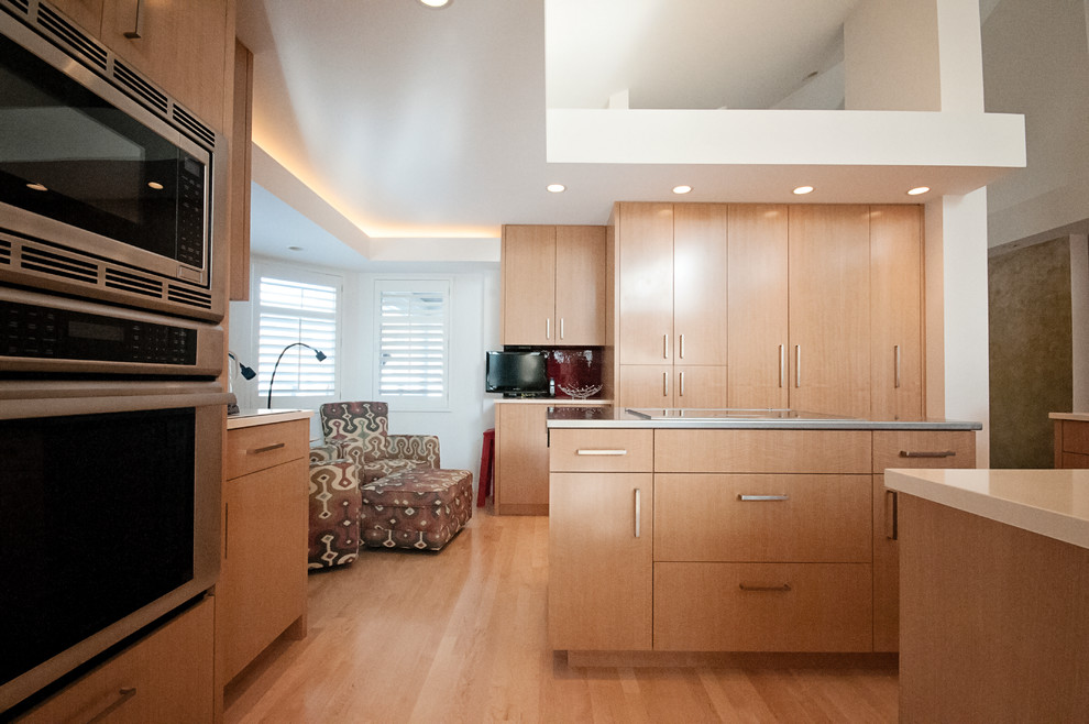 Trendy light wood floor eat-in kitchen photo in Minneapolis with an undermount sink, flat-panel cabinets, light wood cabinets, quartz countertops, red backsplash, ceramic backsplash, stainless steel appliances and two islands