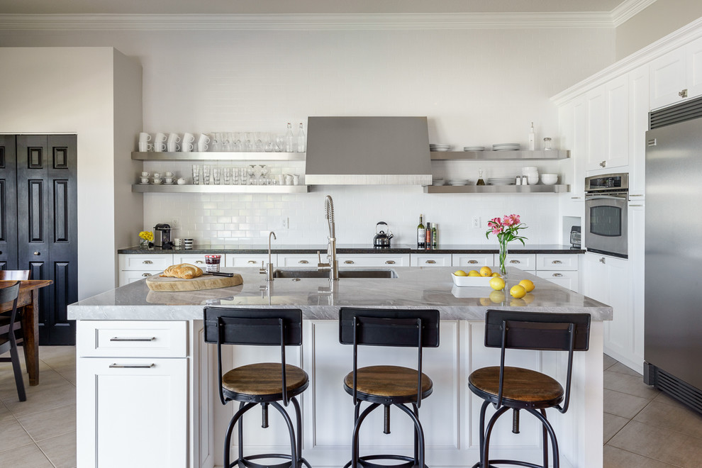 Eat-in kitchen - large traditional galley porcelain tile eat-in kitchen idea in Miami with an undermount sink, shaker cabinets, marble countertops, white backsplash, subway tile backsplash, stainless steel appliances and an island