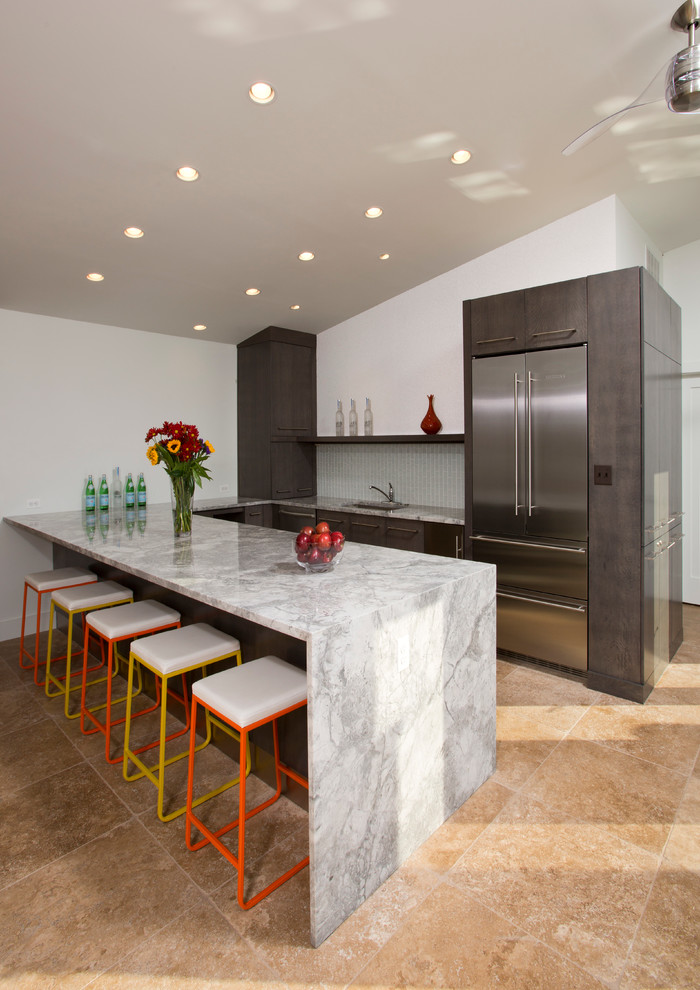 Photo of a contemporary u-shaped open plan kitchen in DC Metro with a submerged sink, flat-panel cabinets, dark wood cabinets, marble worktops, white splashback, glass tiled splashback, stainless steel appliances, travertine flooring, no island and brown floors.