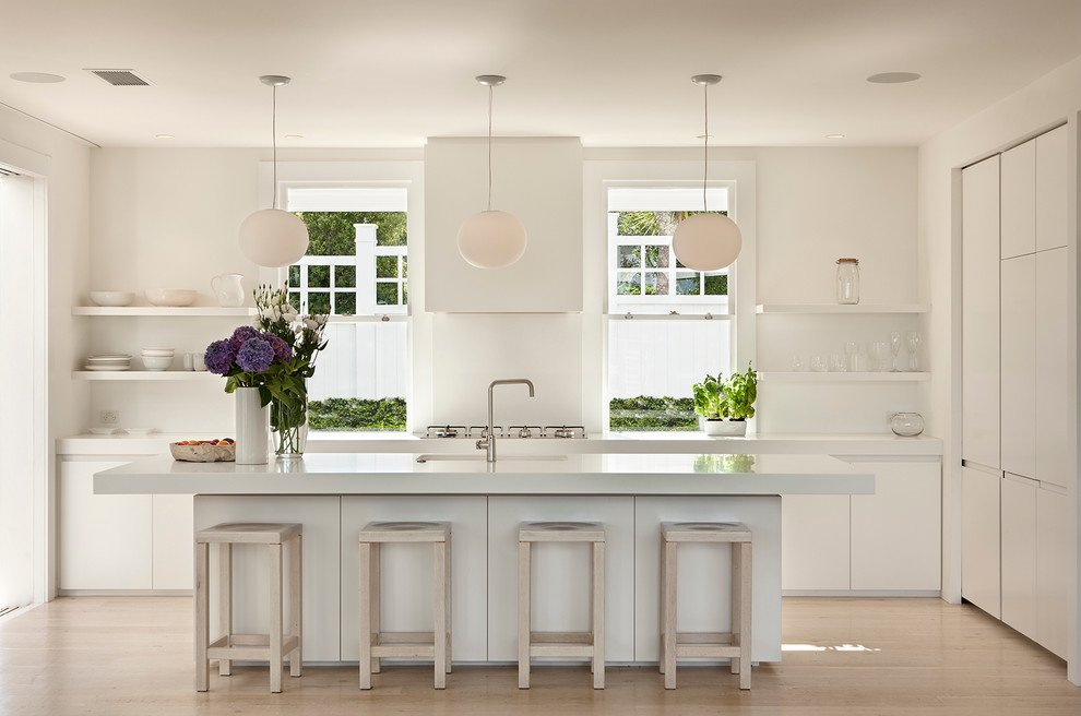 На фото: угловая кухня в современном стиле с врезной мойкой, плоскими фасадами, белыми фасадами и светлым паркетным полом