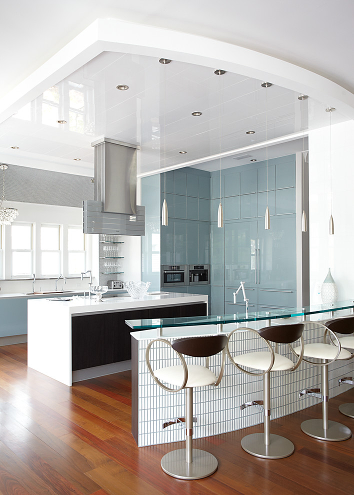 Large trendy u-shaped medium tone wood floor open concept kitchen photo in Miami with an undermount sink, flat-panel cabinets, blue cabinets, metal backsplash, stainless steel appliances and two islands