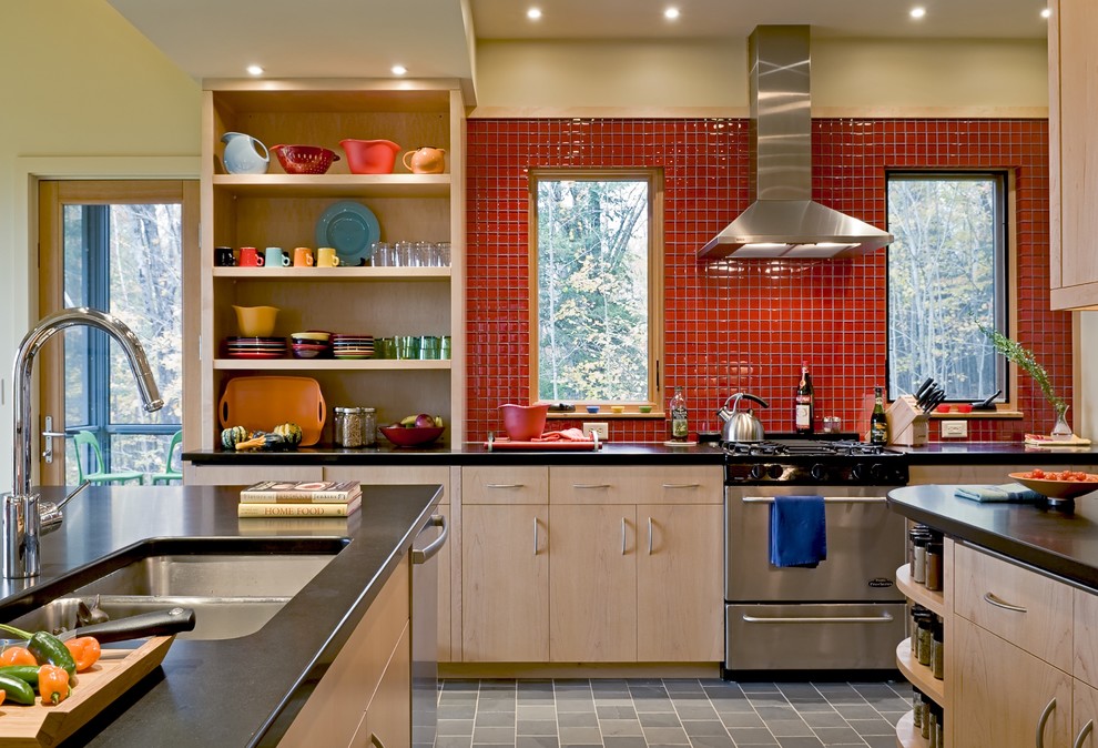 Foto de cocina contemporánea con fregadero bajoencimera, armarios abiertos, electrodomésticos de acero inoxidable, puertas de armario de madera clara y salpicadero rojo