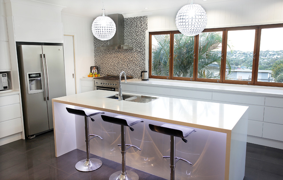 Inspiration for a large contemporary u-shaped kitchen/diner in Brisbane with a submerged sink, white cabinets, engineered stone countertops, metallic splashback, mosaic tiled splashback, stainless steel appliances, porcelain flooring and an island.